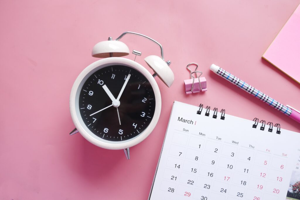 That's an alarm clock and a calendar, overlaid on a pink background.