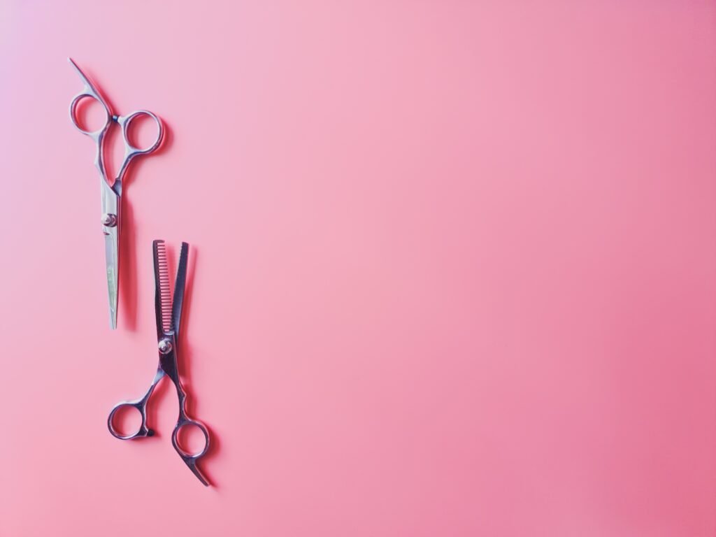 silver scissors on a pink background