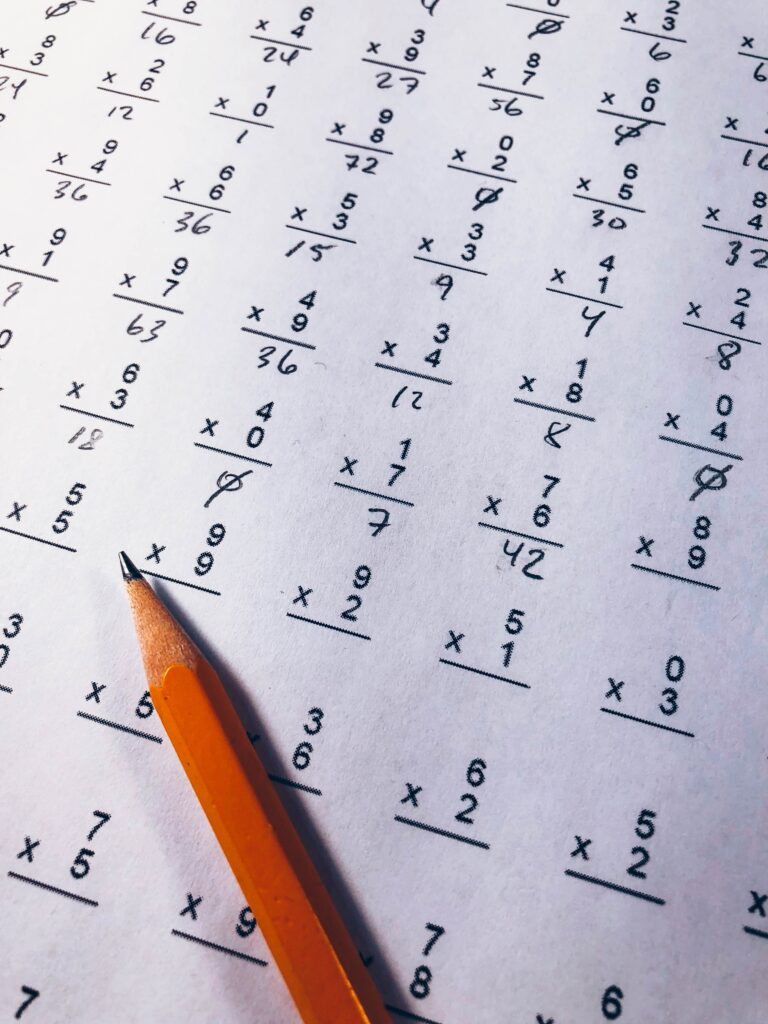 a no. 2 pencil works through math homework on a white sheet of paper