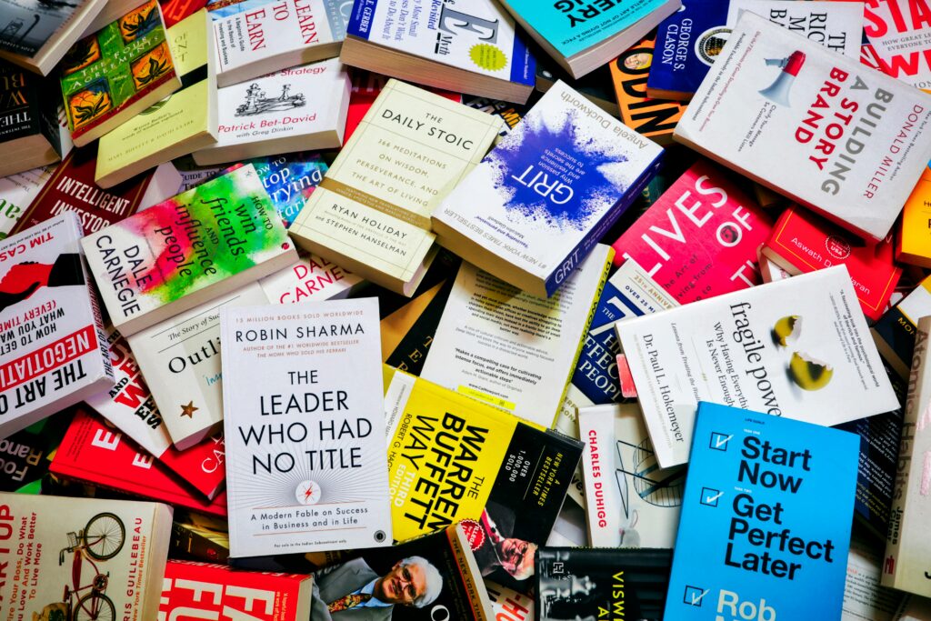 a bunch of business books stacked in a pile